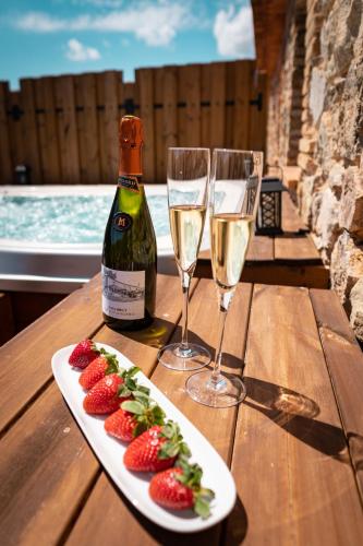 a table with a plate of strawberries and wine glasses at Hotel Mas Mariassa in Pratdip