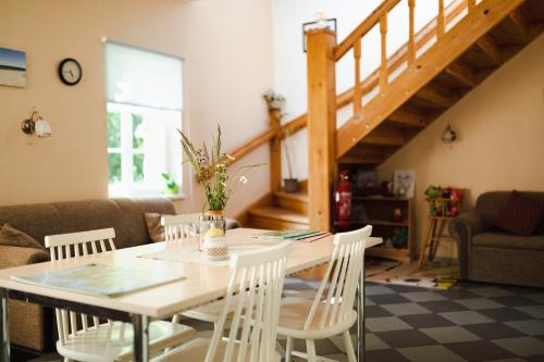 een eetkamer met een tafel en witte stoelen bij Nõva Hostel in Nõva