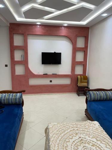 a living room with a flat screen tv on a wall at CASA SANYA RMEL Tetouane in Tetouan