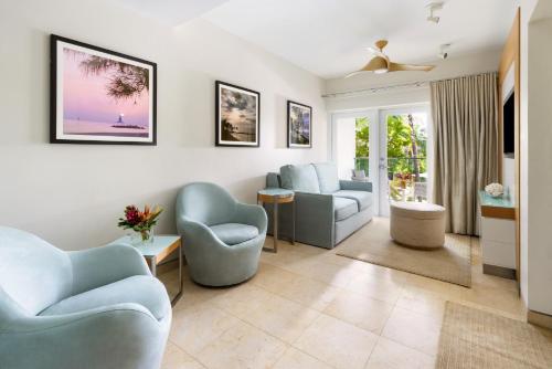 a living room with blue chairs and a couch at Santa Maria Suites Resort in Key West