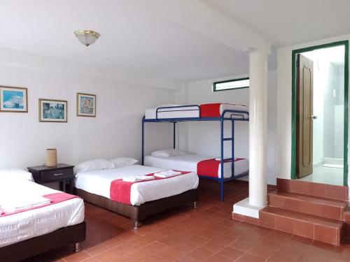 una stanza con tre letti a castello e una finestra di Hotel Villa Carolina a Santa Rosa de Cabal