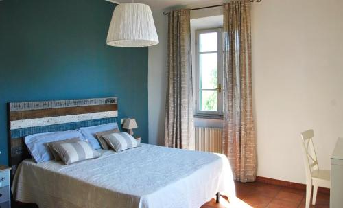 Un dormitorio con una cama con paredes azules y una ventana en LOCANDA FAZIO en Roma