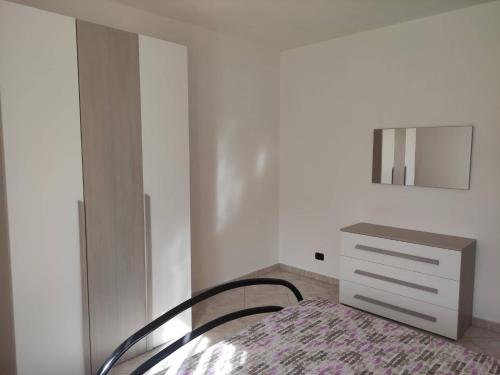 1 dormitorio con 1 cama con tocador y espejo en Casa Vacanze Magnolia, en Scanzano Jonico