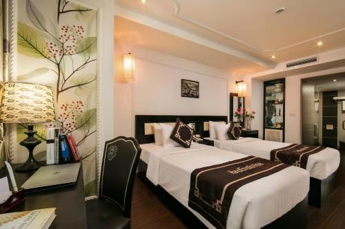 Hanoi Emotion Hotel في هانوي: غرفة فندقية بسريرين ومكتب