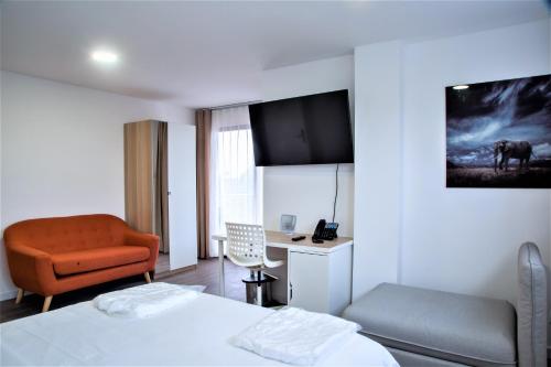 a bedroom with a bed and a chair and a desk at WDC APARTHOTEL - BUEA in Buea