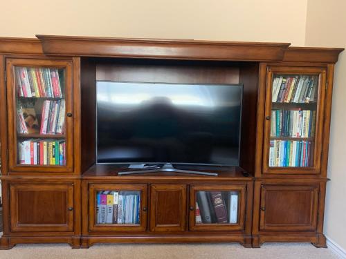 a wooden entertainment center with a flat screen tv at LuxHome Suites in Mansion in Riverside