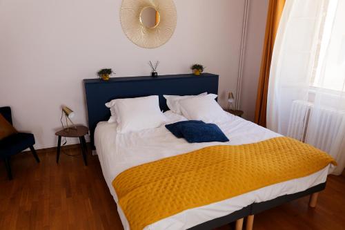 1 dormitorio con 1 cama con manta azul y amarilla en Les chambres de la vallée, en Argenton-Château