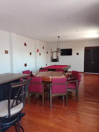 a dining room with a table and pink chairs at Casa de las flores Hotel Boutique in Huajuapan de León