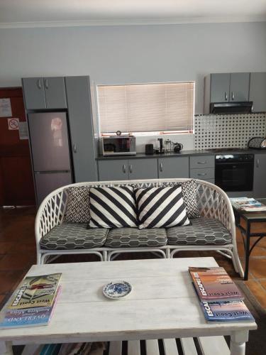 a living room with a couch and a table at Langebaan Sea Cottages in Langebaan