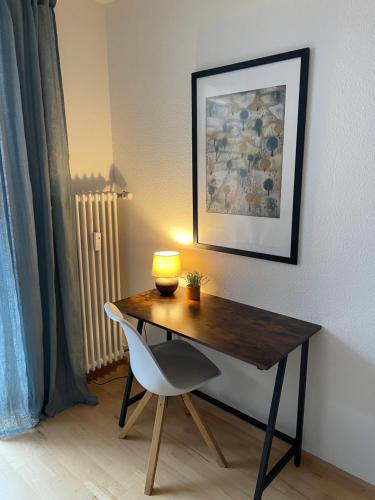 een bureau met een lamp en een stoel in een kamer bij Mida Gästehaus in Freiburg im Breisgau
