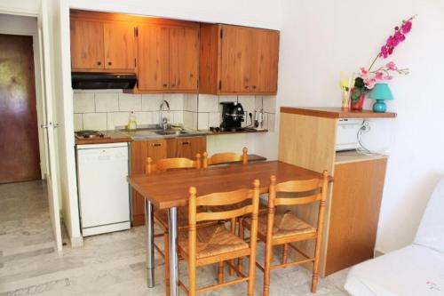 une cuisine avec des placards en bois et une table en bois avec des chaises dans l'établissement HYERES STUDIO 35m² Balcon, à Hyères