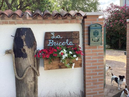 una señal en el lado de un edificio con flores en La Bricola, en Cavallino-Treporti