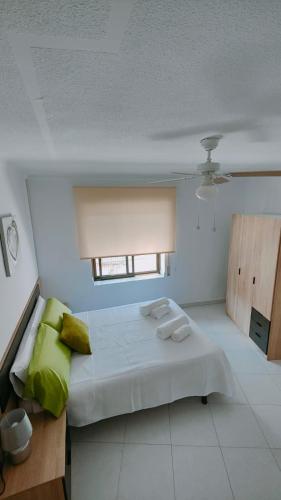 a bedroom with a large white bed with a window at Alojamiento Rural El Peñon de Hornos in Hornos