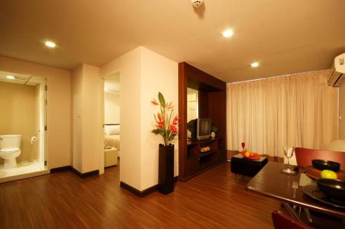 a living room with a toilet and a television at I Residence Hotel Sathorn - SHA Plus in Bangkok