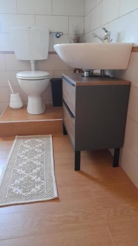 ein Bad mit einem Waschbecken und einem WC in der Unterkunft La_casa_di_ Willy in Canai