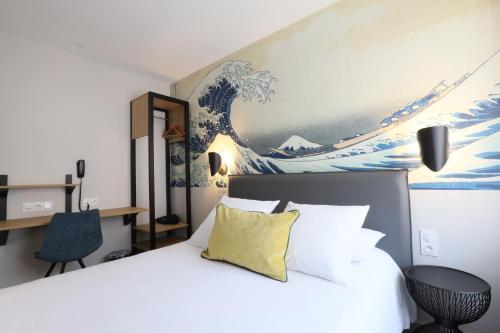 a bedroom with a bed with a painting on the wall at Hôtel la Capelle Millau in Millau
