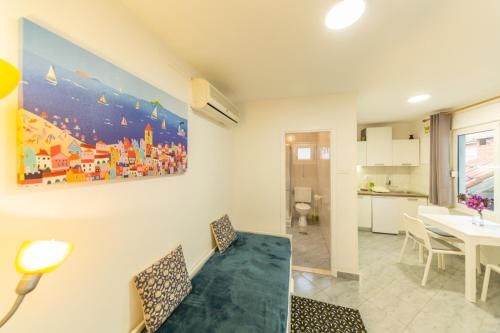 a living room with a dining table and a painting on the wall at Vanja in Komiža