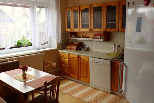 a kitchen with a table and a white refrigerator at Apartman ViVi Pribylina in Liptovský Mikuláš