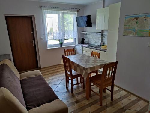 eine Küche und ein Esszimmer mit einem Tisch und einem Sofa in der Unterkunft Domki dla rodzin z dziećmi domkicetniewoPL in Władysławowo