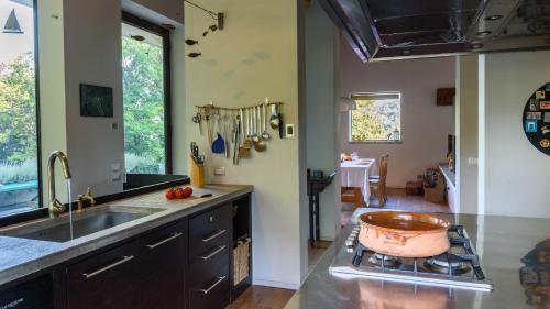 a kitchen with a sink and a pot on the stove at Lago Maggiore Alture di Stresa casa nel bosco confinante con il Golf des iles Borromées in Brisino
