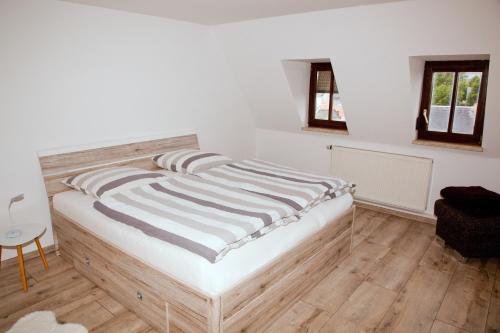 uma cama num quarto com paredes brancas e pisos em madeira em In Triebes em Triebes