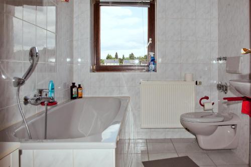 uma casa de banho com uma banheira, um WC e uma janela. em In Triebes em Triebes