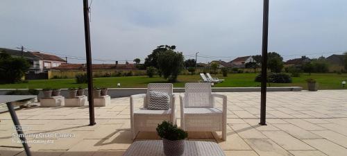 two white chairs sitting on top of a patio at Casa Afonso - Passadiços do Paço in Aveiro
