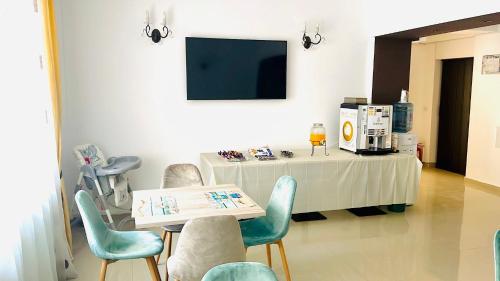 a waiting room with a table and chairs and a tv at Casa Alex in Eforie Nord