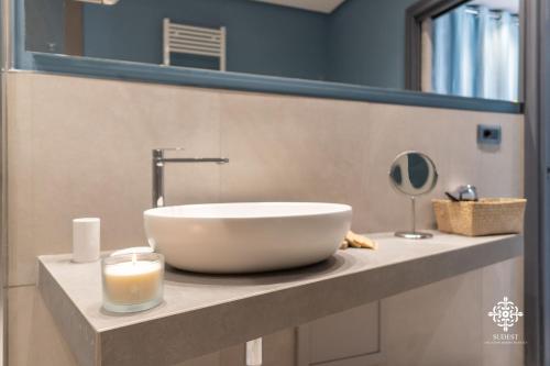 a bathroom with a bowl sink and a candle on a counter at Matteotti Luxury Residence in Siracusa