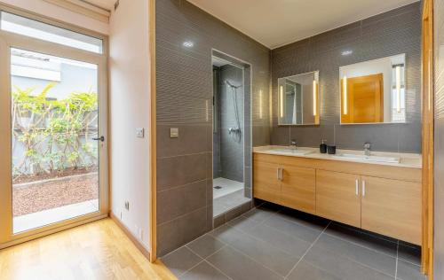 ein Bad mit einer Dusche, 2 Waschbecken und einer Dusche in der Unterkunft Luxury Villa Atlante con piscina climatiza privada in Santa Úrsula