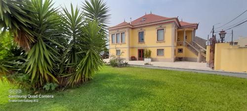 a large yellow house with a green yard at Casa Afonso - Passadiços do Paço in Aveiro