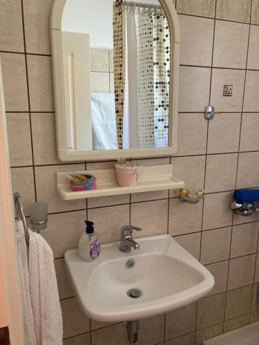 安德羅斯的住宿－AGKYRA Rooms (Love)，一间带水槽和镜子的浴室