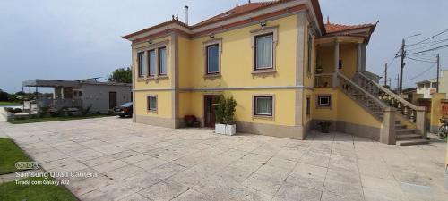 a yellow house with a staircase in a driveway at Casa Afonso - Passadiços do Paço in Aveiro