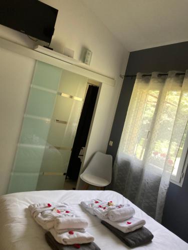 - une chambre avec un lit et des serviettes dans l'établissement Gîte des Combes Blanches avec piscine et jacuzzi, à Frayssinet-le-Gélat