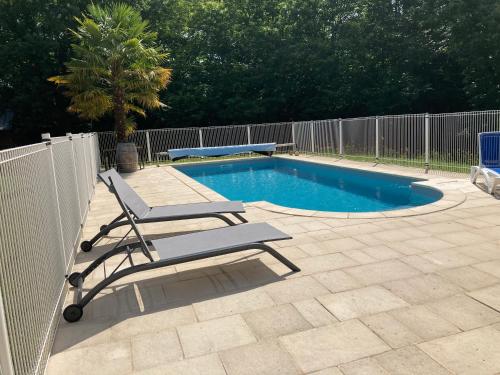 - une piscine avec une chaise et un banc à côté d'une clôture dans l'établissement Gîte des Combes Blanches avec piscine et jacuzzi, à Frayssinet-le-Gélat