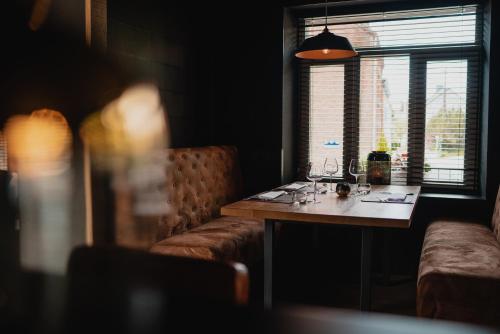 a dining room with a table and a window at Hotel & Restaurant Maison Pal'Ange in Durbuy