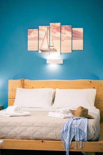 a blue wall with a bed with a hat on it at Sea Salt Apartments in Samos
