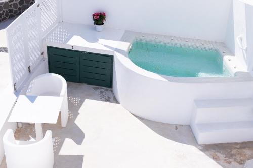 a white bathroom with a tub and a toilet at Avant Garde Suites in Akrotiri