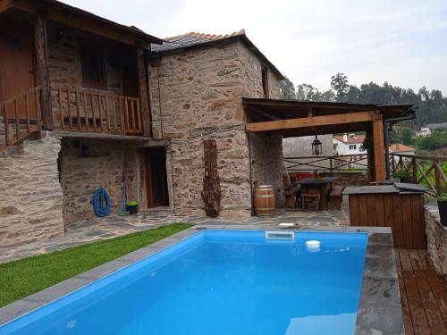 a villa with a swimming pool in front of a house at Casa da Ana - Um refúgio na montanha in Arouca