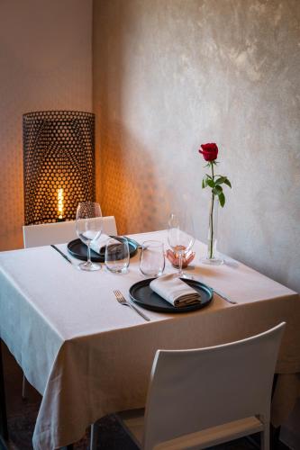 a table with a rose in a vase on it at Hotel Mas Mariassa in Pratdip