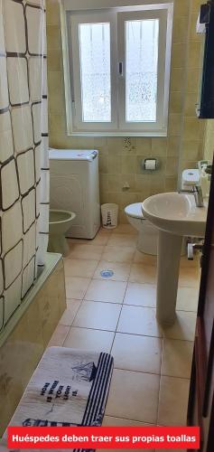 a bathroom with a sink and a toilet and a sink at Carnota PLAYA a 100 metros in Carnota