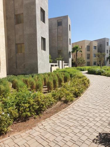 馬拉喀什的住宿－Superbe appart cosy résid privée avec piscine，建筑物前的砖砌走道
