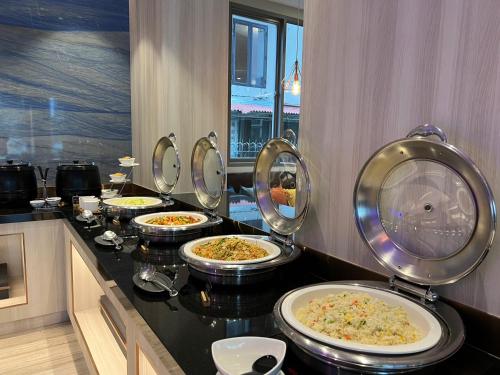 a row of plates of food on a counter in a restaurant at Fifth Pattaya Jomtien By Shiwalai Int in Jomtien Beach