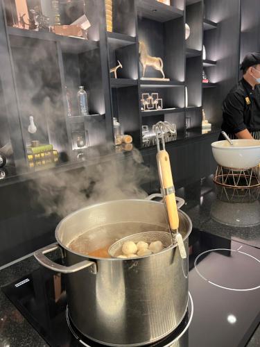 a pot on a stove in a kitchen with smoke at Fifth Pattaya Jomtien By Shiwalai Int in Jomtien Beach