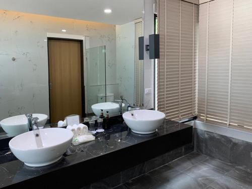 a bathroom with two sinks and two mirrors at Phi Phi Holiday Resort-SHA Extra Plus in Phi Phi Islands