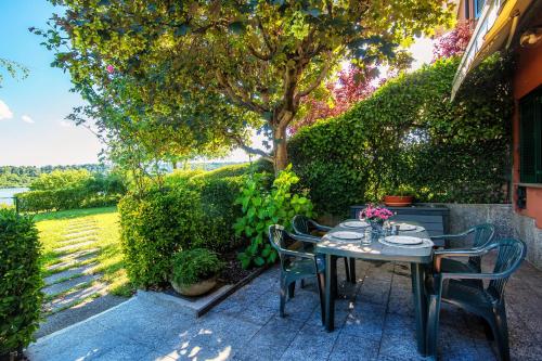 a table and chairs on a patio under a tree at Montorfano By The Lake - My Home In Como in Montorfano
