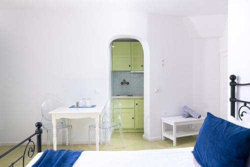 a bedroom with a bed and a table and a sink at Avant Garde Suites in Akrotiri