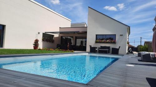 a swimming pool in front of a house at Les Gabions in Chaingy