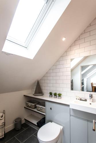 a bathroom with a toilet and a skylight at The Lighthouse Penthouse, Studio and Holiday Home in St Ives