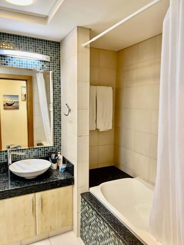a bathroom with a tub and a sink at Luxury Apartment Palm Jumeirah in Dubai